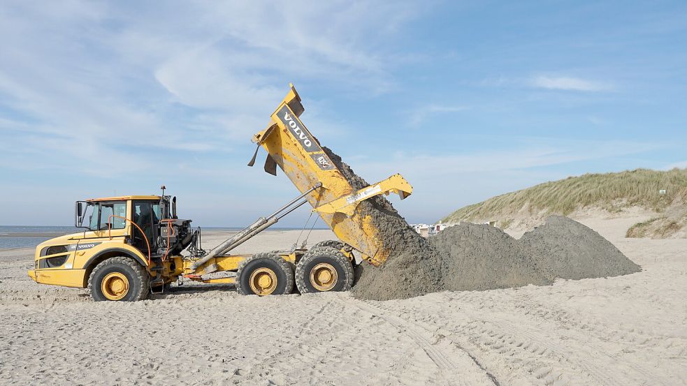 Mit einem Spezialfahrzeug wird auf Baltrum Sand auf den Strand geschüttet. Foto: Bramstedt/dpa