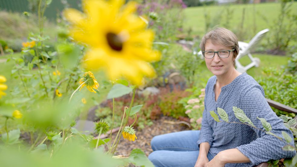 Auf „Tant’ Hannis Bank“ hat Inga Hummelsiep ihren ganzen Garten im Blick. Oft kommen ihr dabei Ideen, was sich noch verbessern lässt. Foto: Ortgies