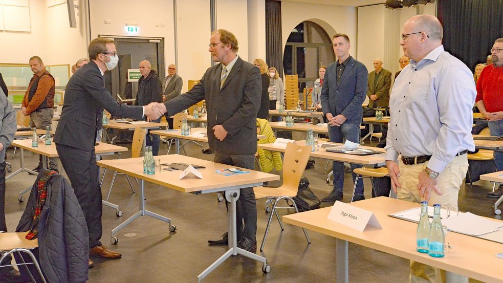 Hendrik Schulz verpflichtete alle Ratsmitglieder mit Handschlag, hier Focko Böden (Mitte, CDU). Foto: Lüppen