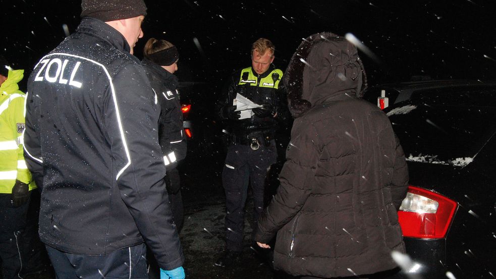 Im Schneegestöber kontrollieren die Beamten sorgfältig alle Unterlagen. Foto: Luppen
