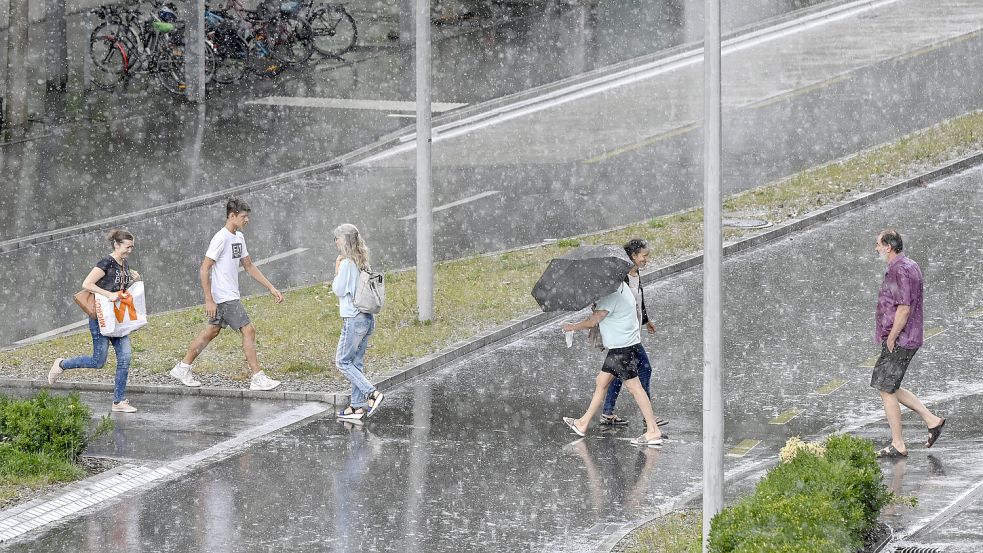 Wenn die Güsse einfach kein Ende mehr nehmen: Fußgänger im Regen. Foto: IMAGO/Pius Koller