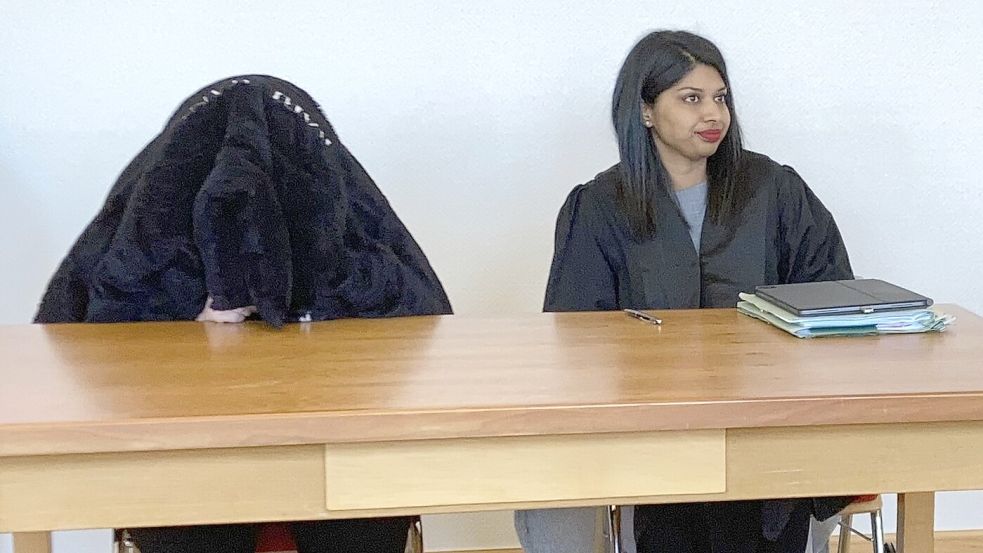 Die 19 Jahre alte Angeklagte sitzt von der eigenen Jacke verhüllt im Amtsgericht Wittmund. Daneben ihre Verteidigerin Irene Gonsalvas. Foto: Oltmanns