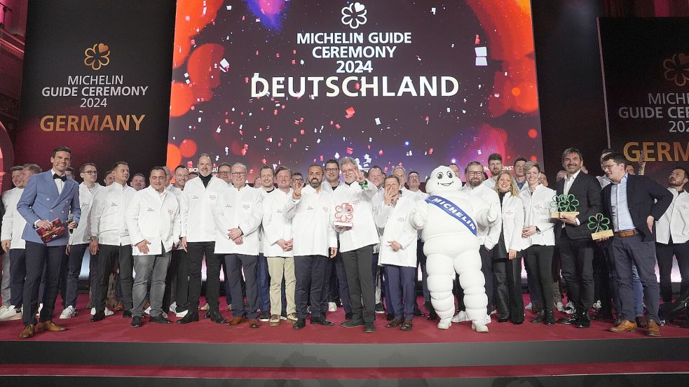 Die Preisträger und Preisträgerinnen stehen nach der Verleihung der Michelin-Sterne 2024 für deutsche Restaurants in der Handelskammer in Hamburg auf der Bühne. Foto: Marcus Brandt/dpa