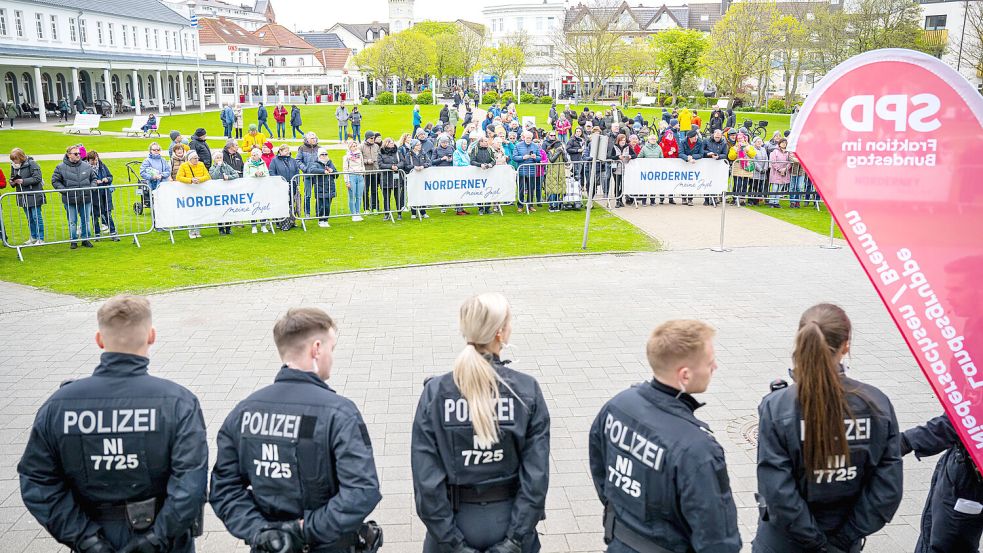 Gut beschützt: Polizeibeamte sichern das Conversationshaus auf Norderney. Zahlreiche Schaulustige sind dabei. Foto: Schuldt/DPA