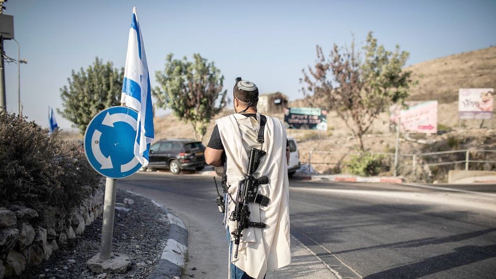 Ein rechtsgerichteter israelischer Siedler trägt eine Waffe nahe der palästinensischen Stadt Nablus im Westjordanland (Archivfoto). Die EU verhängt erstmals Sanktionen wegen der Gewalt radikaler israelischer Siedler. Foto: Ilia Yefimovich/dpa