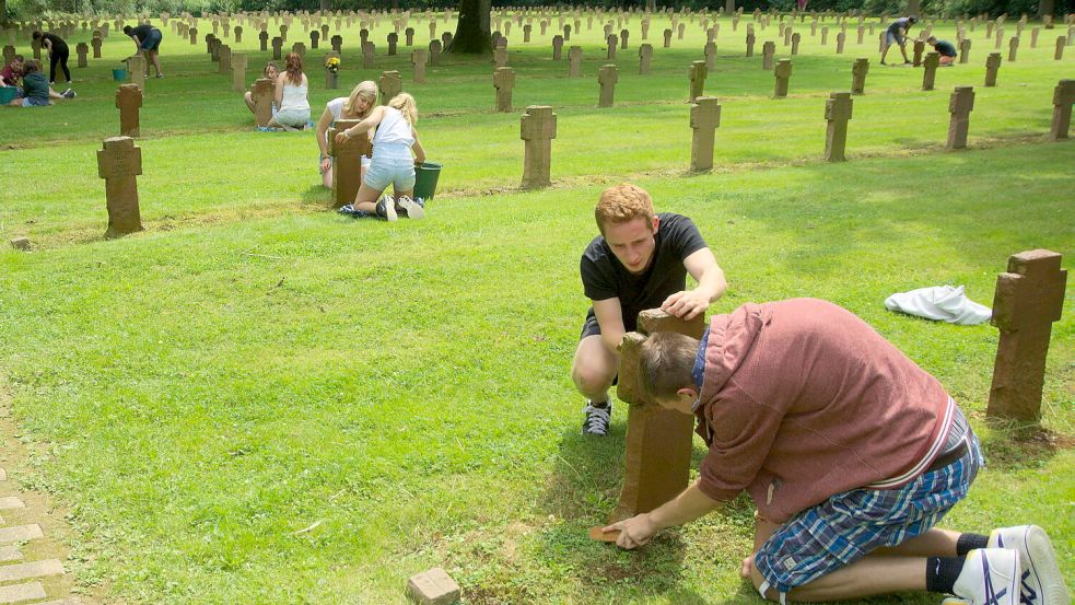 Junge Leute bei der Pflege von Kriegsgräbern auf dem deutschen Soldatenfriedhof im französischen St. Désir. Foto: Archiv