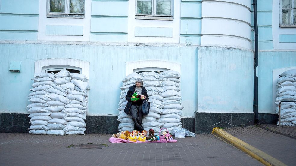 Kiew ist eine Stadt der Gegensätze geworden: Vor mit Sandsäcken geschützten Fenstern verkauft eine Frau Spielzeug. Die Ukraine verteidigt sich nun seit 796 Tagen gegen den russischen Angriffskrieg. Foto: Francisco Seco/AP/dpa