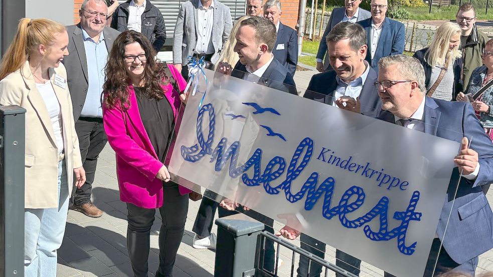 Für die Leiterin der Kinderkrippe „Inselnest“, Svenja Kreklau (links), gab es zur Eröffnung ein großes Schild.