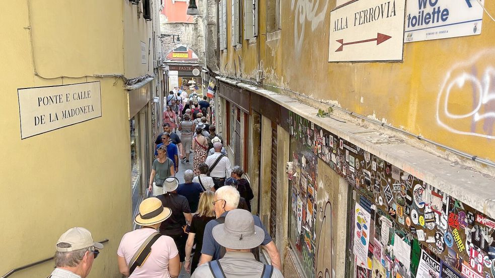 Besucher drängen sich in der „Calle de la Madoneta“, eine der engen Gassen Venedigs. Foto: Christoph Sator/dpa