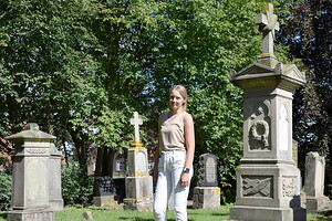 Ines Lindemann steht neben einem besonders prächtigen Grabstein auf dem historischen Friedhof in Warsingsfehn. Bilder: Kluth