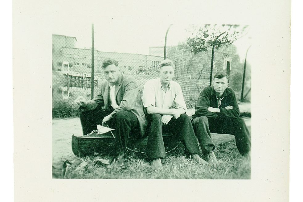 Auf einem Paddelboot sitzen (von links) die „Brenner“ Karl Pötzinger, Johann Niemann und Siegfried Graetschus am Zaun der „T4“-Anstalt Brandenburg. Im Hintergrund das Stadtbad, Sommer 1940. „Brandenburg“ notierte Niemann im Fotoalbum darunter.