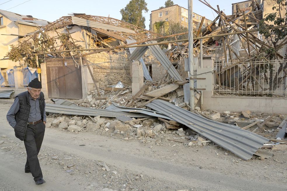 Ein Mann geht an einem Haus in Stepanakert, der Hauptstadt der Region Berg-Karabach, vorbei. Es wurde durch aserbaidschanische Artillerie zerstört. Bild: Uncredited/AP/DPA