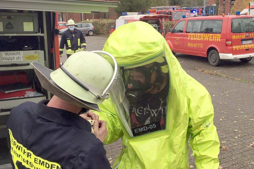 Bevor sich die Männer dem Behälter nähern, werden ihnen neongelbe Schutzanzüge übergezogen. Bild: Päschel