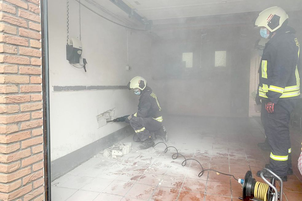 Die Feuerwehrleute schnitten ein Loch in die Wand der Garage. Fotos: Feuerwehr