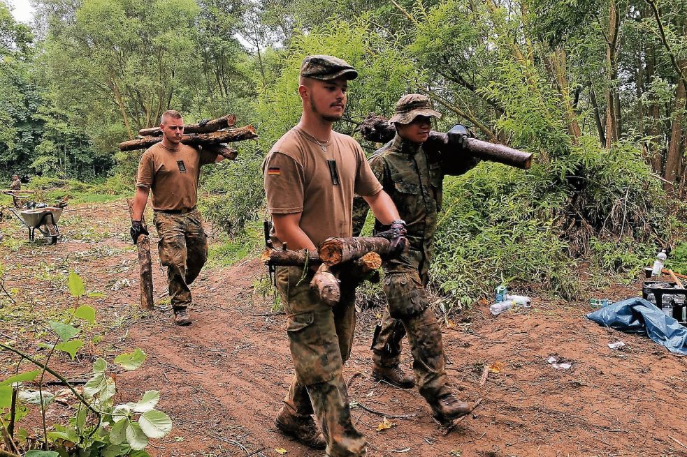 Die Soldaten der Bundeswehr müssen das Totholz teilweise per Hand wegschaffen, weil die Bagger auf dem durchweichten Gelände nicht fahren können. Fotos: Polat