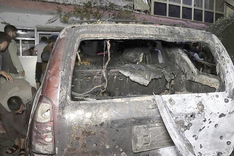 Personen betrachten ein ausgebranntes Fahrzeug in Kabul, das bei einem amerikanischen Drohnenangriff ins Visier genommen wurde. Foto: Khwaja Tawfiq Sediqi/AP/dpa