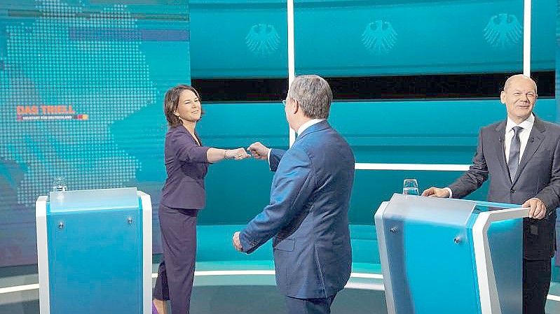 Die Kanzlerkandidaten Armin Laschet (mitte, CDU), Annalena Baerbock (l., Bündnis 90/Die Grünen) und Olaf Scholz (SPD) begrüßen sich vor der Sendung im Fernseh-Studio in Berlin-Adlershof. Foto: Michael Kappeler/dpa Pool/dpa