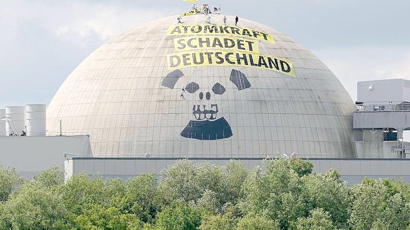 Zwanzig Aktivisten der internationalen Umweltschutzorganisation Greenpeace befinden sich auf der Kuppel des Reaktorgebäudes des Atomkraftwerkes Unterweser in der Wesermarsch. Foto: Ingo Wagner/dpa