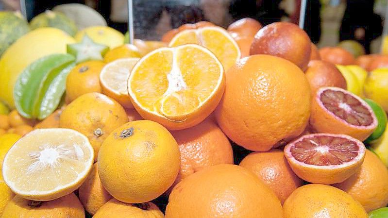 Orangen liegen mit anderen Zitrusfrüchten in Körben auf der Messe "Grüne Woche". Foto: Felix Zahn/dpa