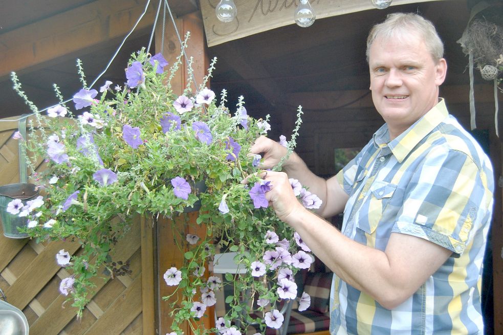 Für das Foto stellt sich Thomas Erdwiens zu der Petunie. Die Pflege der heimischen Blumen überlässt er aber lieber seiner Frau. Foto: Boschbach