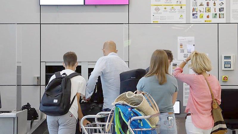 Fluggäste geben im Abflugbereich des Flughafens von Palma de Mallorca am Eurowings-Schalter ihre Koffer ab. Foto: Clara Margais/dpa