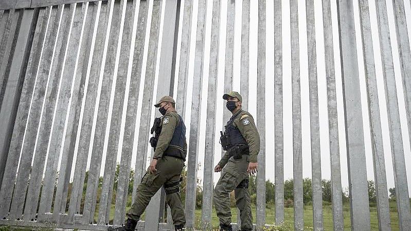 Polizeibeamte patrouillieren entlang eines Grenzzauns entlang der griechisch-türkischen Grenze. Foto: Giannis Papanikos/AP/dpa