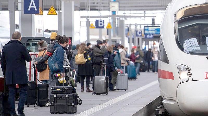 Reisende neben einem ICE am Münchener Hauptbahnhof. Foto: Sven Hoppe/dpa