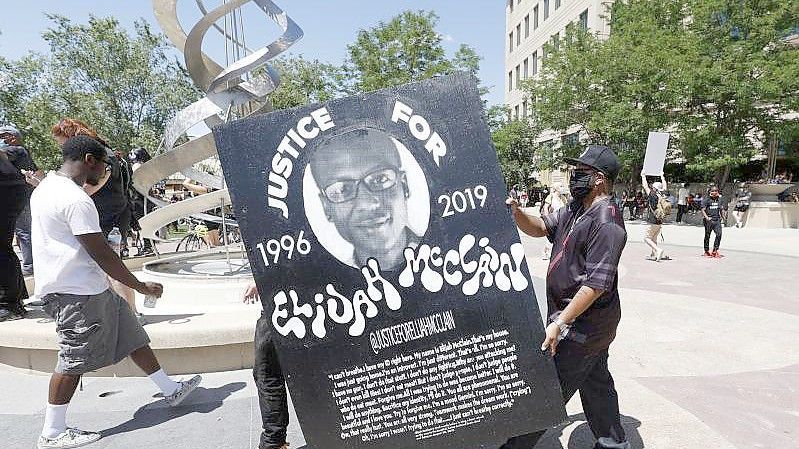 Demonstranten tragen während einer Kundgebung vor dem Polizeirevier wegen des Todes von Elijah McClain ein Plakat mit dessen Bild. Foto: David Zalubowski/AP/dpa