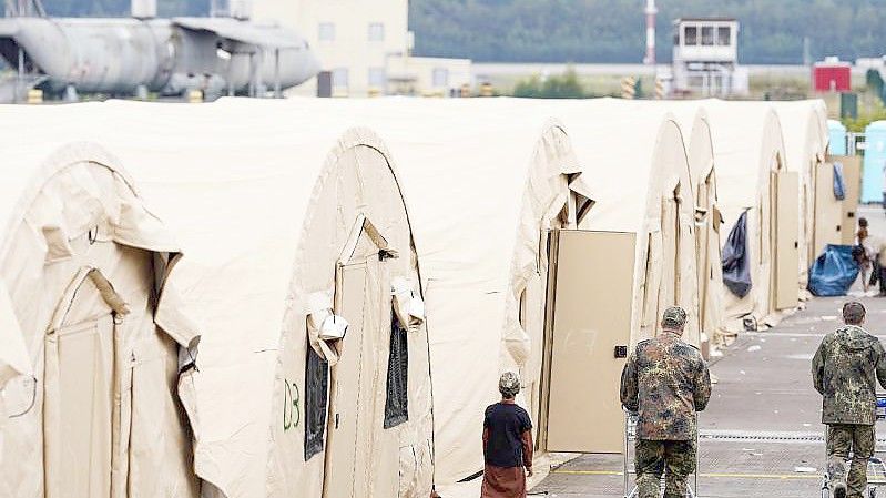 US-Soldaten gehen auf der Ramstein Air Base mit Einkaufswagen an einer Reihe von Zelten vorbei. Foto: Uwe Anspach/dpa