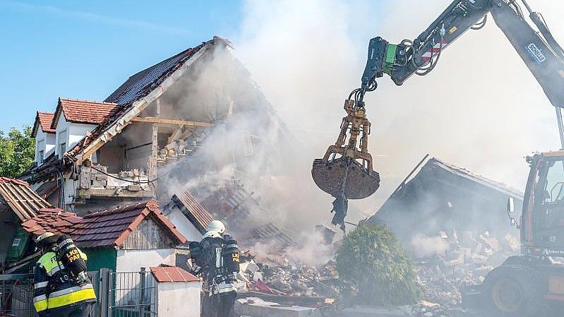 Ein Bagger räumt Teile des eingestürzten Hauses weg. Foto: Armin Weigel/dpa