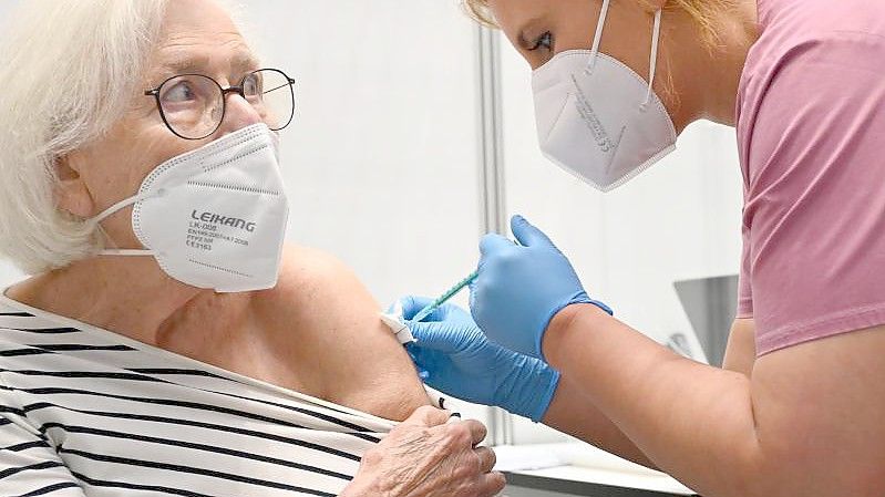 Claudia Kreil (r) vom Impfzentrum am Robert-Bosch-Krankenhaus in Stuttgart verabreicht einer Patientin die Auffrischimpfung gegen das Coronavirus. Foto: Bernd Weißbrod/dpa