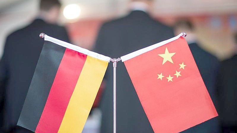 Eine chinesische und eine deutsche Flagge stehen am bei einem Empfang im chinesischen Hefei (China). Foto: picture alliance/Ole Spata/dpa