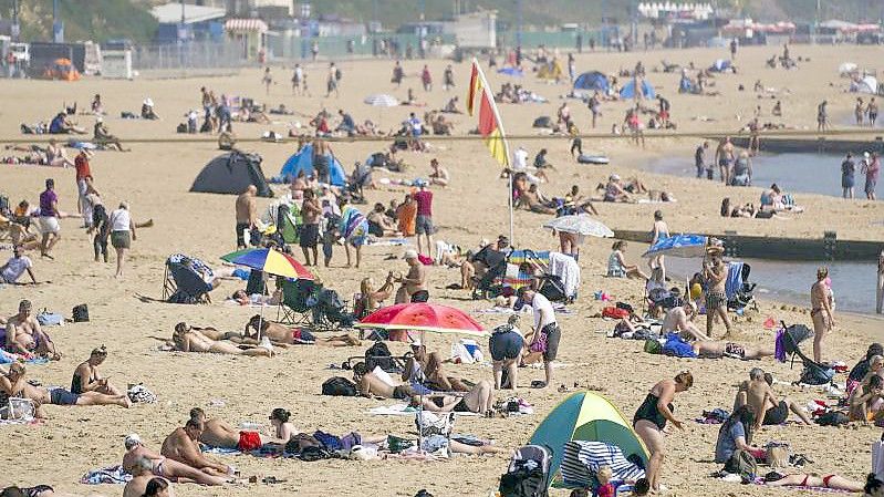 Zahlreiche Menschen genießen das warme Wetter am Strand von Bournemouth. Foto: Steve Parsons/PA Wire/dpa