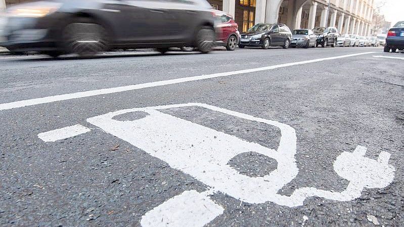 Ein Symbol für ein Elektroauto markiert einen Parkplatz neben einer E-Ladesäule. Foto: Julian Stratenschulte/dpa
