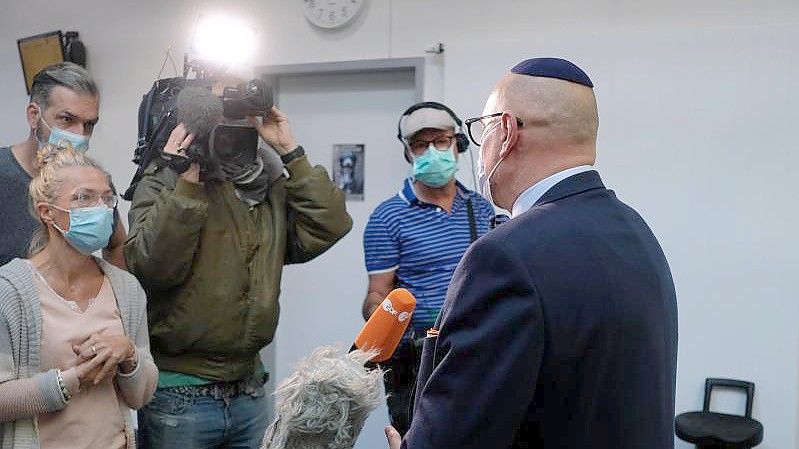 Uwe Dziuballa (r.), Chef des jüdischen Restaurants „Schalom“, spricht im Amtsgericht mit Medienvertretern. Foto: Sebastian Willnow/dpa-Zentralbild/dpa