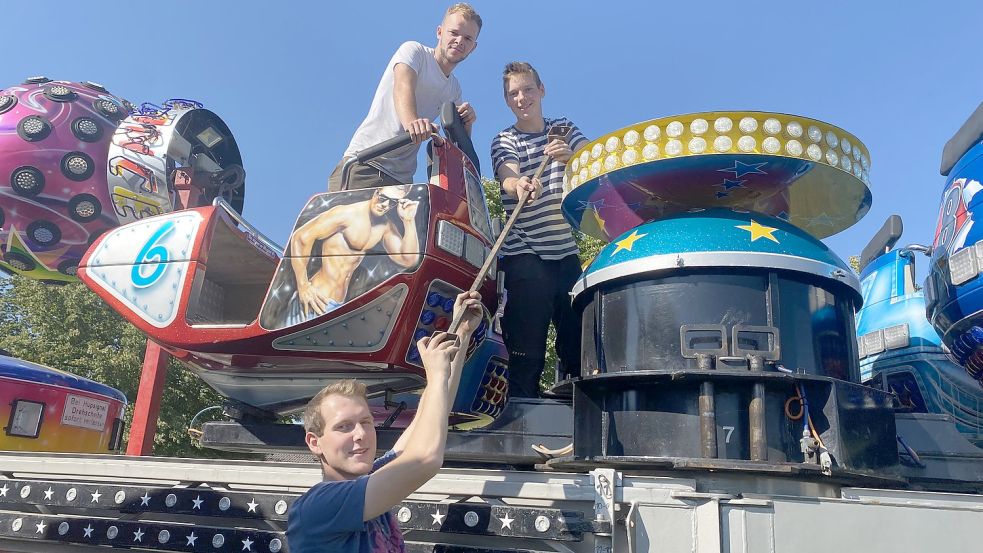 Alex Leontesco (oben links), Jimmy-Jake Piontek und Moritz Piontek (unten) bauen das Fahrgeschäft „Break Dancer“ auf dem Schützenplatz in Emden auf. Foto: Tomé