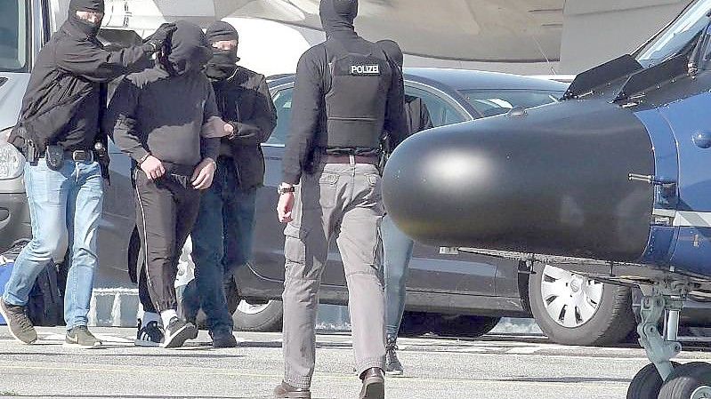 Ein mutmaßliches Mitglied der Terrormiliz IS wird auf dem Flughafen Hamburg zu einem Hubschrauber der Bundespolizei gebracht. Foto: Bodo Marks/dpa