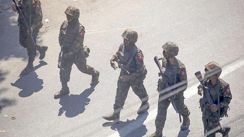 Soldaten gehen im März während eines Protestes gegen den Militärputsch in Myanmar über eine Straße. Symbolbild. Foto: Str/AP/dpa