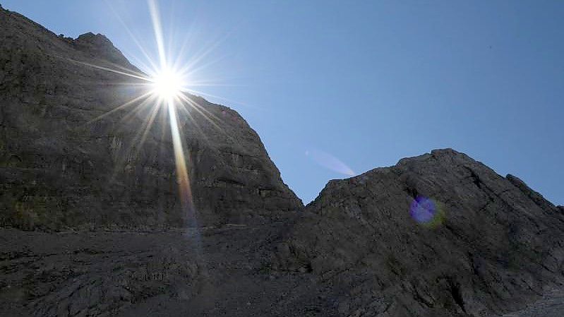 Die Sonne kommt am Morgen hinter einem Felsen im Watzmannkar (Bayern) hervor. Foto: Angelika Warmuth/dpa