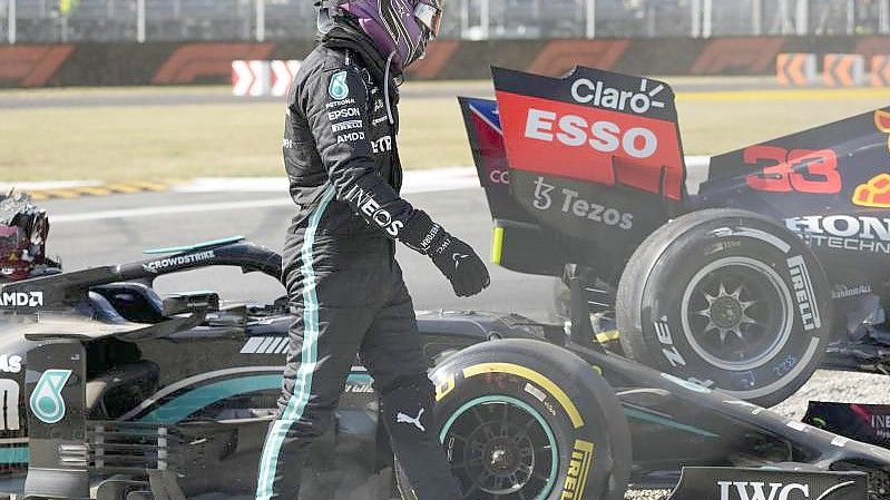 Lewis Hamilton vom Team Mercedes geht nach einem Zusammenstoß mit Red-Bull-Racing-Fahrer Verstappen an seinem Rennwagen vorbei. Foto: Luca Bruno/AP/dpa