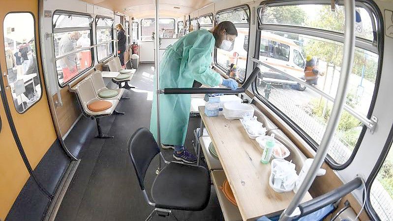 Eine medizisch-technische Assistentin bereitet in einem stillgelegten Schwebebahnwagen in Wuppertal Corona-Impfungen vor. Eine bundesweite Impfaktionswoche soll neue Fortschritte bringen. Foto: Roberto Pfeil/dpa