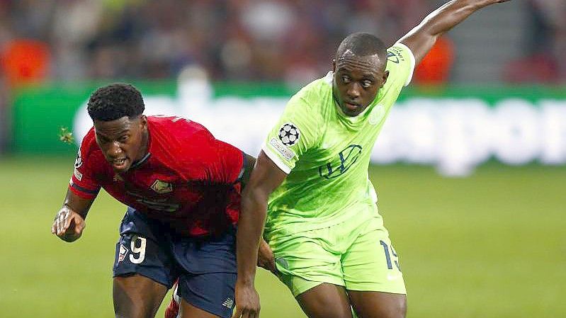 Jonathan David (l) vom OSC Lille gegen Kevin Mbabu vom VfL Wolfsburg. Foto: Michel Spingler/AP/dpa