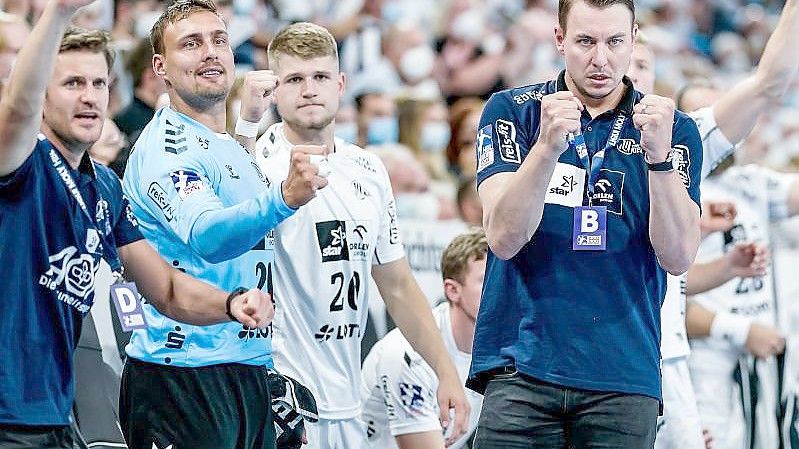 Kiels Trainer Filip Jicha (r) bejubelt gemeinsam mit seinem Asssistenzteam und den Ersatzspielern einen Treffer. Foto: Axel Heimken/dpa/Archivbild