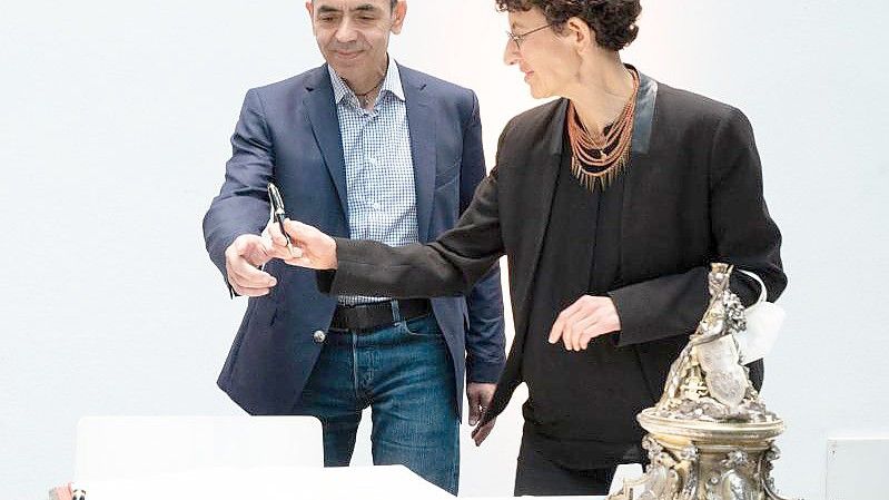 Ugur Sahin (l) und Özlem Türeci tragen sich in das Goldene Buch der Stadt Köln ein. Foto: Federico Gambarini/dpa