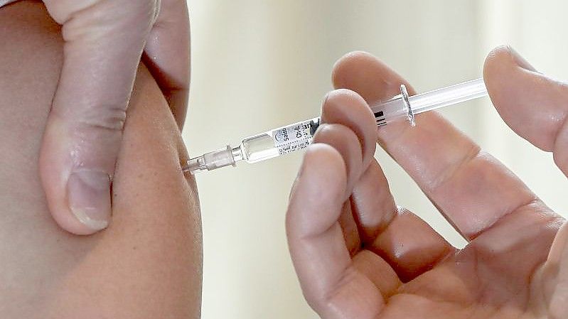 Ein Arzt impft eine Patientin gegen Grippe. Foto: Jens Kalaene/dpa-Zentralbild/dpa