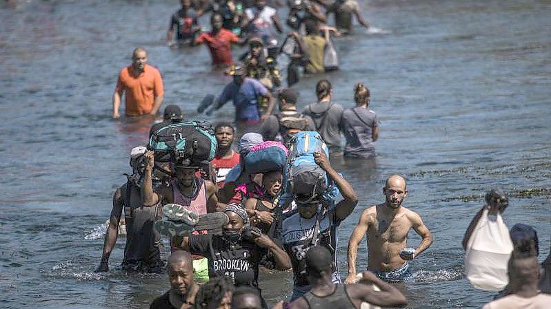 Migranten waten durch den Rio Grande und hoffen auf Zuflucht in den USA. Foto: Felix Marquez/AP/dpa