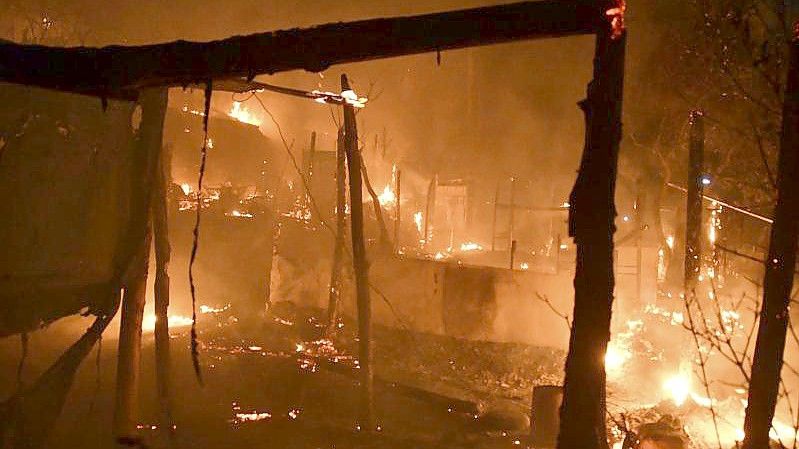 Feuer brennt behelfsmäßige Zelte außerhalb des überfüllten Flüchtlingslagers am Hafen von Vathy auf der ostägäischen Insel Samos ab. Foto: Michael Svarnias/AP/dpa