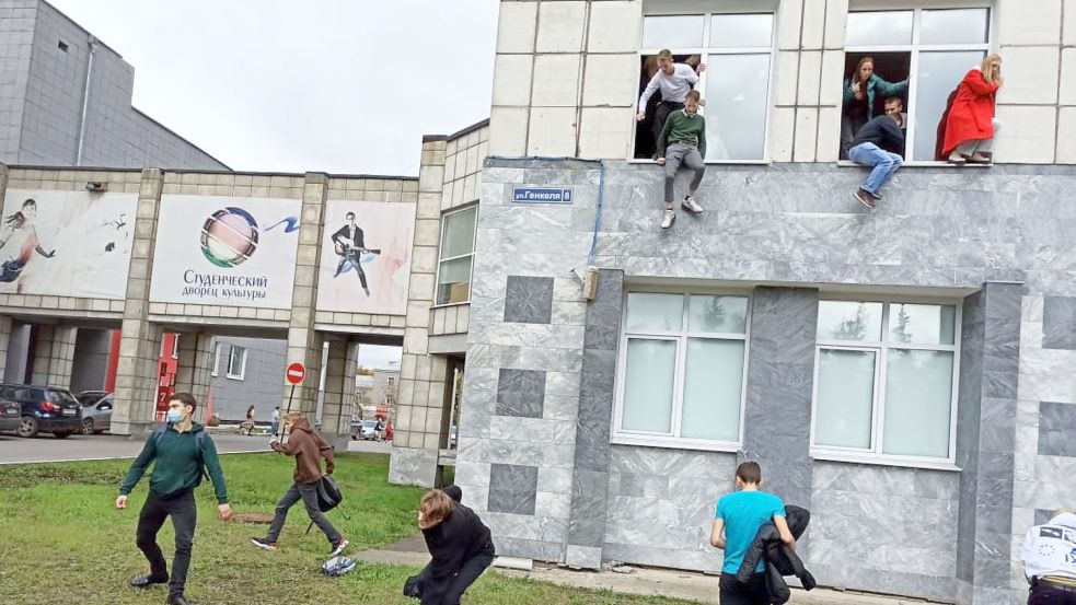 Studenten springen während des Angriffs aus dem Fenster einer Universität. Foto: Alexey Romanov/dpa