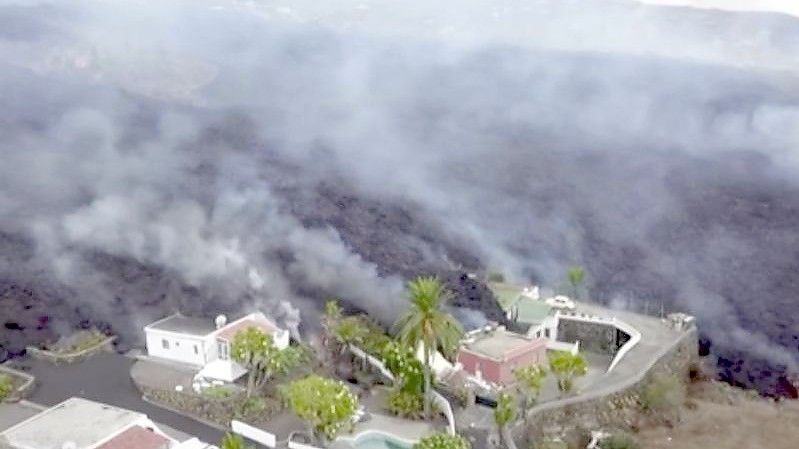 Häuser an einem Hang werden von Lava zerstört. Erstmals seit 50 Jahren ist auf der spanischen Kanareninsel La Palma wieder ein Vulkan ausgebrochen. Foto: Uncredited/OVERON/dpa