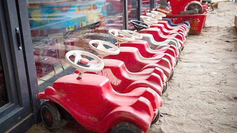 Mehrere Bobbycars stehen auf dem Spielplatz eines Kindergartens. Foto: Christian Charisius/dpa/Symbolbild